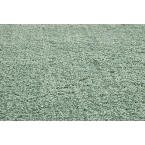 Dettaglio di un morbido tappeto a pelo lungo in poliestere verde salvia. Trama fitta e soffice, altezza pelo 1,5 cm.