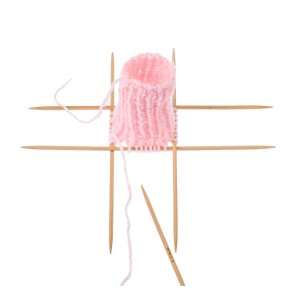 Laine bébé rose (50g) sur aiguilles à tricoter. Idéale pour tricoter des vêtements et accessoires pour bébés.