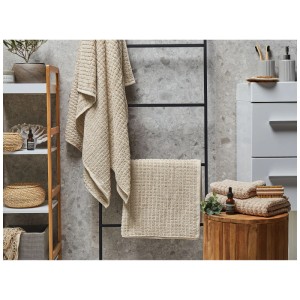 Ensemble de 4 serviettes de bain Beliani Atai en coton beige dans une salle de bain.