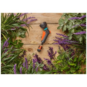 Set doccia Gardena Classic 2 pezzi con doccetta e raccordo water-stop, circondato da piante.