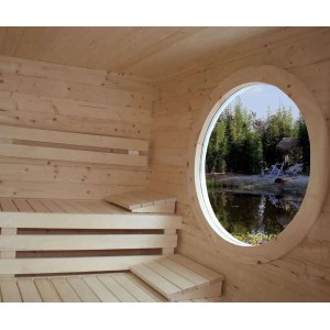 Vue intérieure du sauna de jardin Finntherm Cubus-70 B avec bancs et fenêtre ronde donnant sur le jardin.