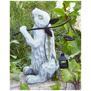 Graue Osterhasenfigur aus Magnesiumoxid mit Laterne, handgefertigt, als Gartendekoration im Grünen.