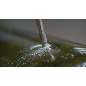 Punta diamantata Dremel 662 fora vetro scuro, generando polvere bianca. Ideale per incisioni su vetro.