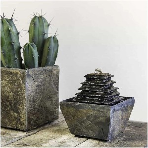 Fontaine d'intérieur Climaqua Sumi en ardoise naturelle en forme de pyramide, à côté d'un cactus.