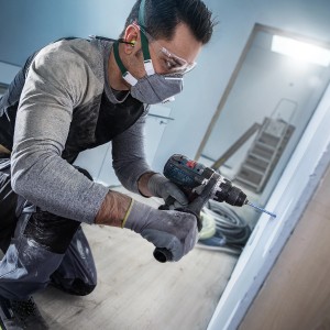 Artisan perçant un trou dans le mur avec un foret universel Bosch Expert CYL-9.