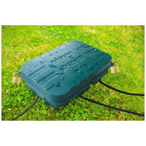 Boîte de câbles verte IP55 taille L avec deux cadenas sur l'herbe. Boîte multiprise étanche pour l'extérieur.