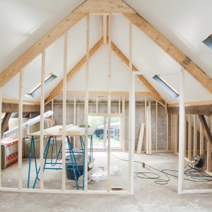 Aménagement de combles avec bois de construction en douglas, construction à ossature bois avec fenêtre.