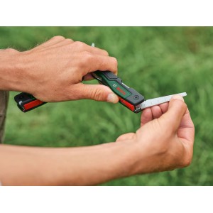 Multi-outil Bosch 16-en-1 en utilisation : Accessoire pour outils multifonctions avec fonction de mesure.