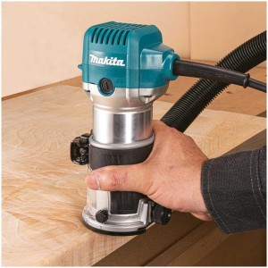 Défonceuse à une main Makita RT0702CX2J en action, fraisage de chants sur bois.