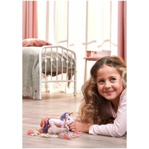 Bambina gioca con unicorno Schleich Bayala Seraphina (70892). Pelliccia rosa, criniera viola, corno dorato.