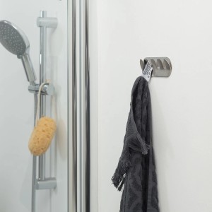 Porte-serviettes Tiger Rack Round en acier inoxydable brossé avec serviette grise dans la salle de bain.