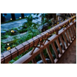 Guirlande solaire LED Schönenberger noire avec 120 LED blanc chaud sur une balustrade.