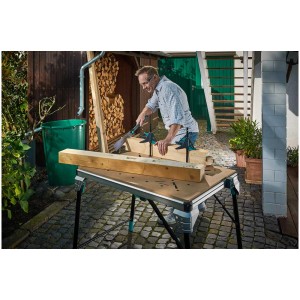 Banco da lavoro Wolfcraft Master Work 1600 con uomo che sega legno in giardino.