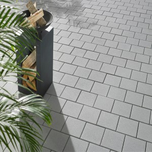 Pavé Kann Vero Maxx gris argenté 20x20x7,5 cm posé avec décoration en bois. Pavé moderne pour jardin et terrasse.