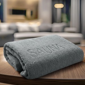 Serviette de sauna grise en coton (70x200 cm) avec inscription 'SAUNA'.