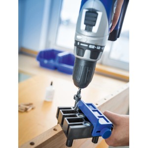 Gabarit de perçage LUX Classic en plastique utilisé avec une perceuse pour des assemblages précis.