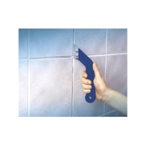 Main tenant un gratte-joints LUX carbure Classic sur des carreaux. Outil pour nettoyer les joints de carrelage.