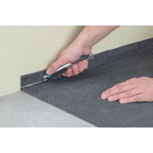 Wolfcraft Profi-Trapezklingen-Messer Autoload in uso per tagliare un rivestimento per pavimenti.