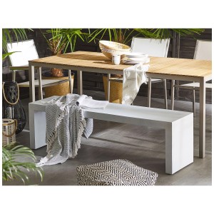 Banc de jardin moderne Beliani Taranto en béton blanc avec couverture et coussin en extérieur.