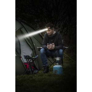 Homme en camping avec lampe frontale Energizer Vision HD. Lumière vive, idéal pour activités extérieures.