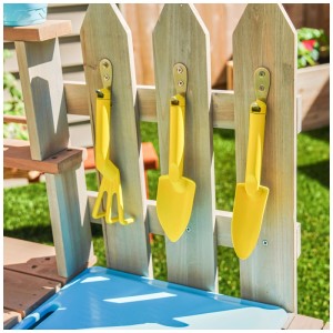 KidKraft stazione da giardino per bambini Greenville con rastrello e pale gialle sulla staccionata.