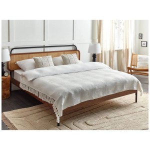 Coperta Beliani Chaohani color crema (150x200 cm) con frange su un letto.