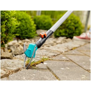 Gardena combisystem Raschietto per fughe 2in1 in uso: rimozione erbacce tra le pietre di pavimentazione.
