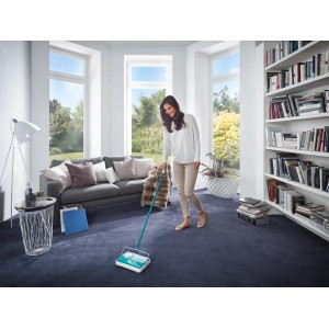 Donna che utilizza il battitappeto Leifheit Regulus per pulire un tappeto blu.