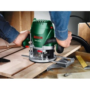 Fresatrice verticale Bosch POF 1200 AE che esegue una scanalatura nel legno.