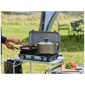 Fornello da campeggio Campingaz Kitchen 2 Maxi in uso con pentola e padella all'aperto.