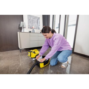 Femme insérant un sac filtrant en non-tissé dans un aspirateur Kärcher WD 1 Compact Battery.