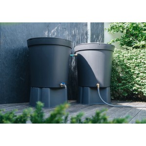 Deux récupérateurs d'eau de pluie gris avec kit de raccordement Geka dans le jardin. Idéal pour la récupération d'eau.