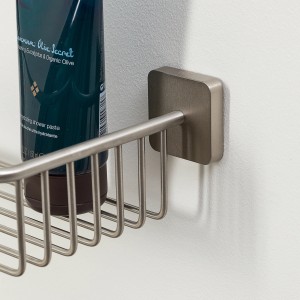 Étagère de douche Tiger Onu en acier inoxydable brossé avec gel douche sur mur blanc.