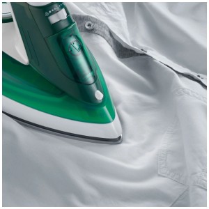 Ferro da stiro a vapore Severin BA3261 verde e bianco mentre stira una camicia bianca.