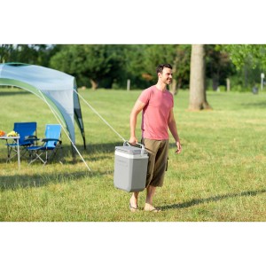 Graue Thermoelektrische Kühlbox Powerbox Plus 28 l von Campingaz im Einsatz im Grünen.