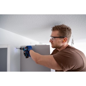 Uomo che fora un muro con trapano avvitatore a percussione Bosch Professional GSB 12V-35.