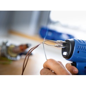 Set de pistolet à souder LUX-TOOLS 100 W en action lors du soudage de câbles.