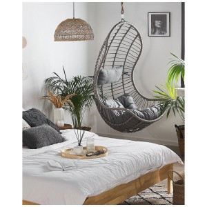 Sedia sospesa Beliani Pineto in rattan grigio con cuscini in camera da letto.