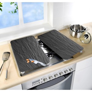 Set di 2 coperture per piano cottura Wenko effetto ardesia su un fornello, decorato con coltello e mandorle.