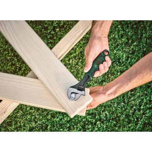 Clé à molette Bosch en utilisation : clé sur construction en bois sur pelouse. Clés et extracteurs.