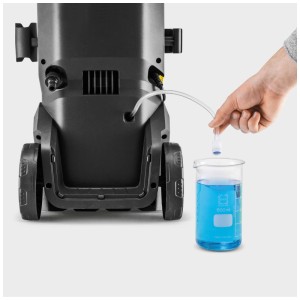 Idropulitrice Kärcher K 5 WCM con tubo di aspirazione in un becher con detergente.