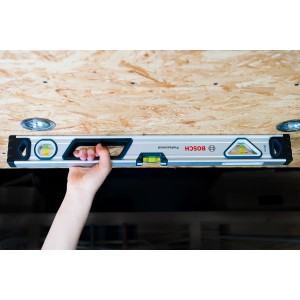Bosch Professional Wasserwaage (60 cm) im Einsatz, gehalten von einer Hand. Ideal für präzise Messungen.