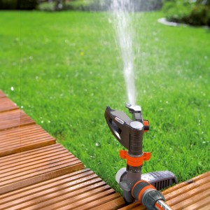 Arroseur Gardena Comfort arrosant la pelouse. Arroseur à impulsion, circulaire et sectoriel en utilisation.