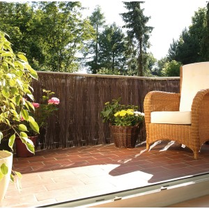 Brise-vue Videx Husum, 90x300 cm, comme écran de balcon avec plantes et fauteuil.