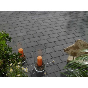 Pavés Vero Graphite 6 cm gris posés en extérieur avec décoration.
