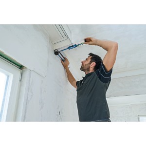 Mesure d'angle numérique Bosch Professional GAM 220 en cours d'utilisation pour mesurer un angle sur un mur.