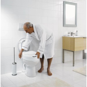 Un homme installe un rehausseur de siège de toilette Ridder blanc (100 mm) dans la salle de bain.