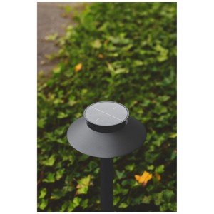 Schwarze Nordlux Solar-Pollerleuchte Justina aus Edelstahl, 60 cm, mit Bewegungsmelder vor Grün.