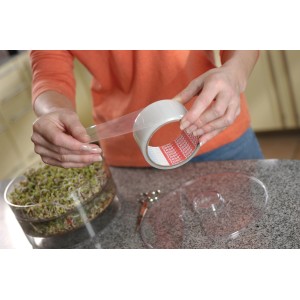 Femme utilisant du ruban adhésif transparent Tesa Extra Power pour réparer une plaque transparente.