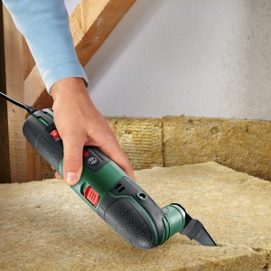 Outil multifonction Bosch PMF 220 CE en utilisation, coupant un matériau isolant.